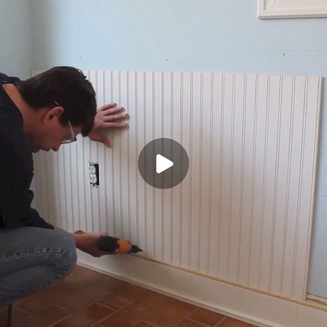 a man is working on the wall in his home