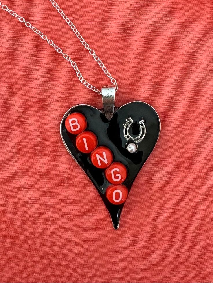 I created this unique piece using a silver tone heart and added artist sculpting putty and charms and mini letters I added a mini horseshoe and gave it a glossy coat of resin for shine and a lasting durable coat The heart hangs from a silver This one of a kind pendant would be a great gift for a bingo playing friend or yourself Personalized Silver Enamel Charm Necklace, Personalized Silver Charm Necklace In Enamel, Personalized Silver Charm Necklace With Enamel, Heart-shaped Silver Enamel Jewelry, Silver Enamel Heart Pendant Necklace, Silver Heart-shaped Enamel Jewelry, Heart-shaped Enamel Charms Necklaces, Heart-shaped Enamel Charms Necklace, Enamel Heart Charms Necklace