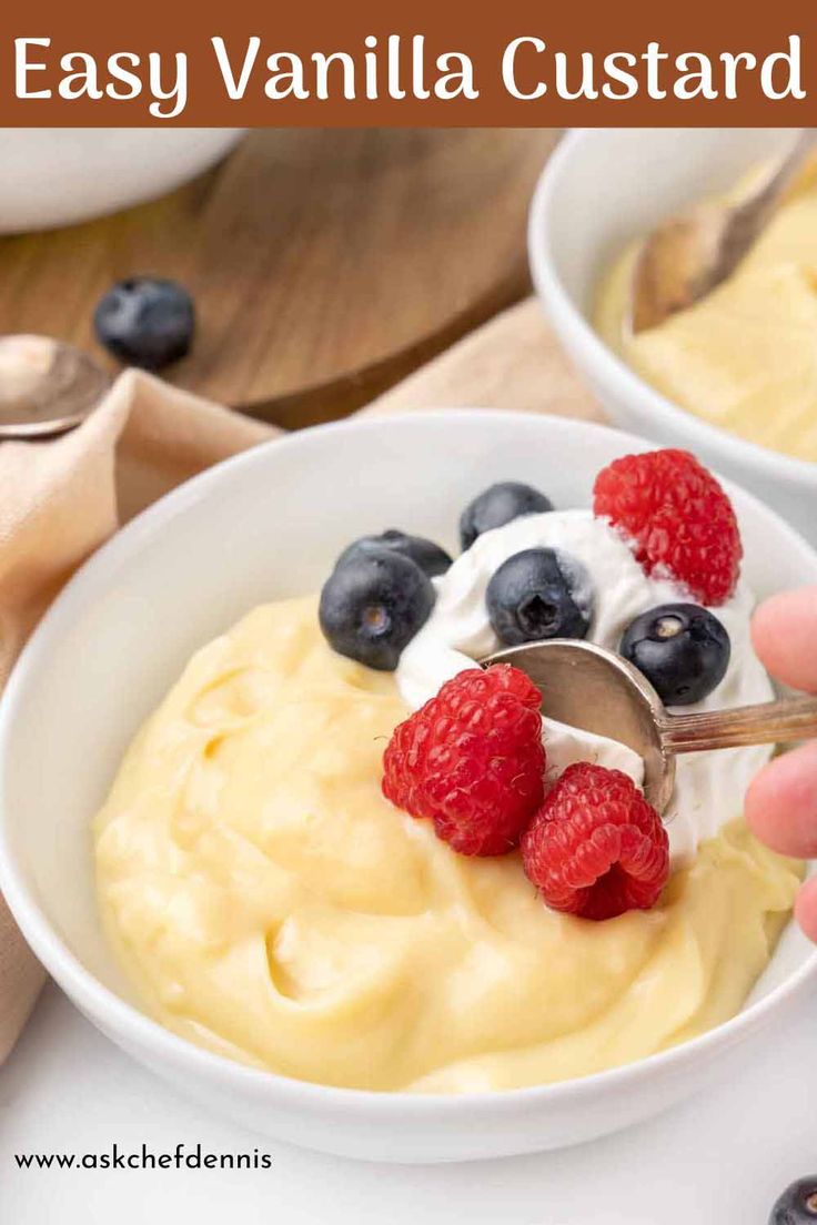 a bowl of yogurt with berries and raspberries on top, being spooned into it