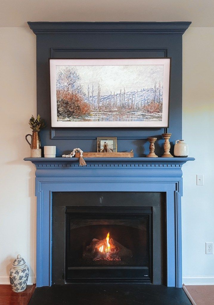 a fireplace with a painting on the mantle