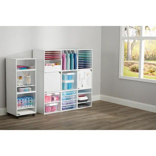 a white bookcase filled with lots of books next to a window in a room