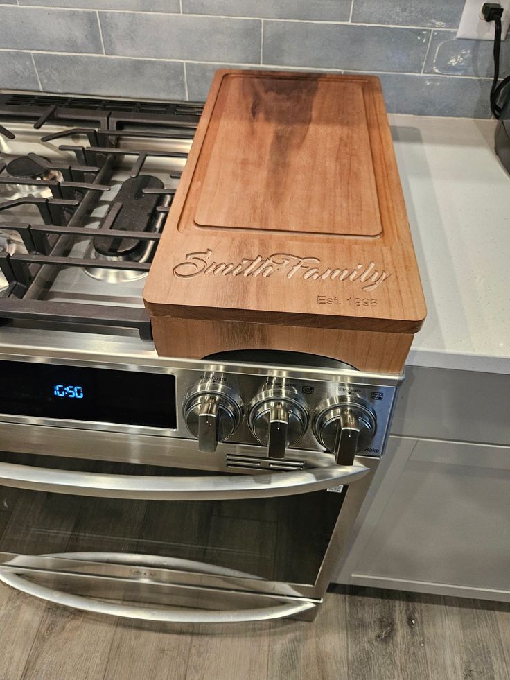 a wooden cutting board sitting on top of an oven