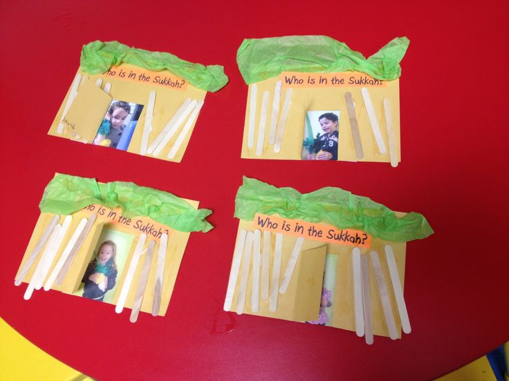 four popsicles with pictures on them sitting on a red table top next to a yellow paper bag