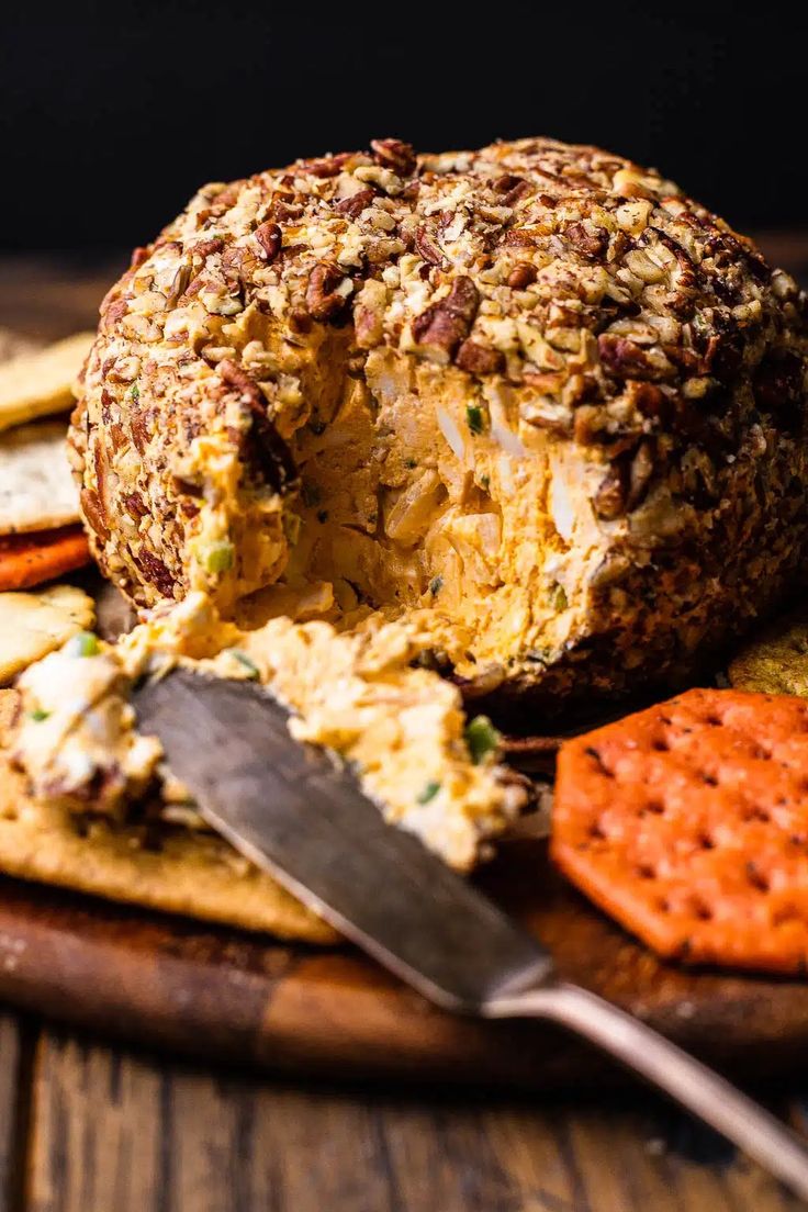 a cheese ball on a cutting board with crackers