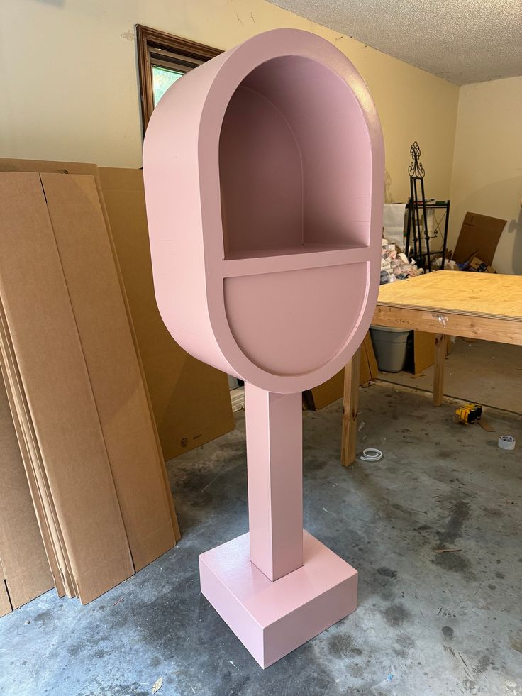 a pink mailbox sitting in the middle of a room