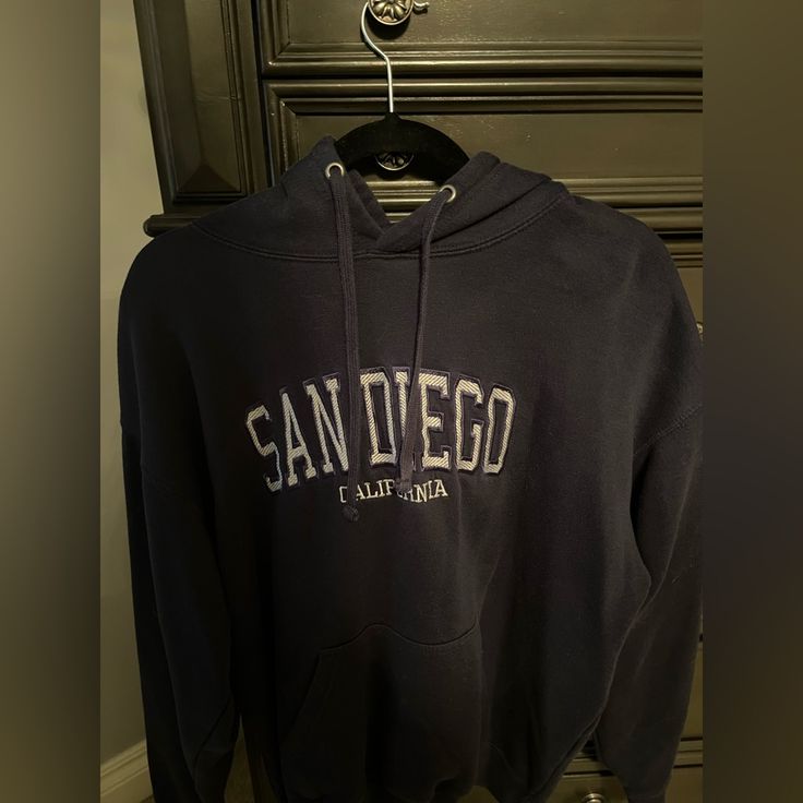 San Diego, California Navy Blue Hoodie. Only Worn Three Times And In Perfect Condition. Comes From A Smoke Free Home. Not Nwt. Size Medium. Navy Letter Print Hoodie Sweatshirt, Cozy Blue Sweatshirt With Letter Print, Blue Varsity Hoodie, Blue Varsity Hoodie With Drawstring Hood, Navy Long Sleeve Hoodie With Letter Print, Trendy Blue College Hoodie, Trendy Blue Hoodie For College, Blue Winter College Style Sweatshirt, Casual Blue Tops For Winter