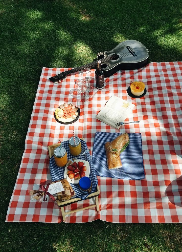 a picnic blanket with food and drinks on it