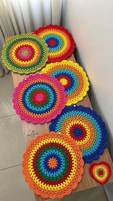 four crocheted placemats sitting on a wooden table next to a radiator