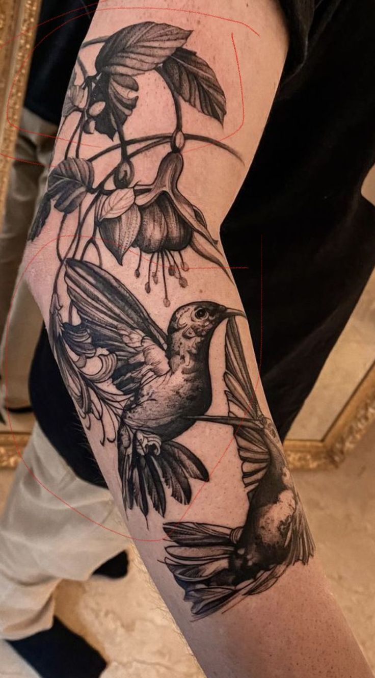 a black and white photo of a bird on a branch with flowers