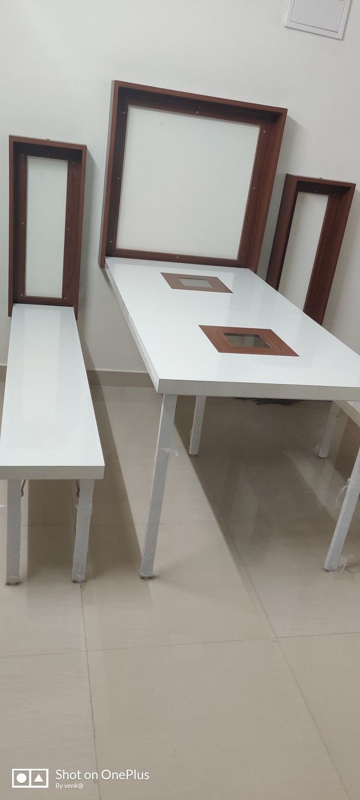 three white tables and two brown framed pictures