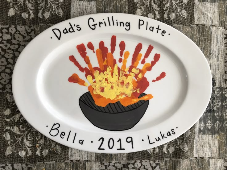 a white plate with handprints on it that says dad's grilling plate