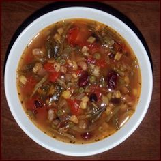 a white bowl filled with soup on top of a wooden table