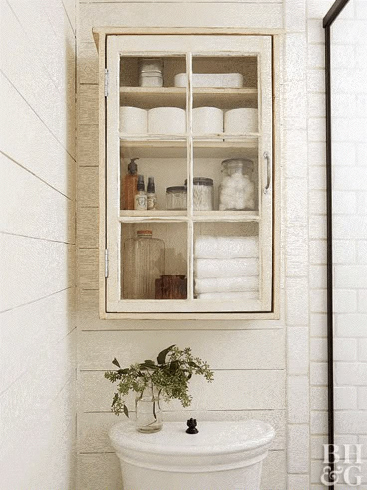 a bathroom with white tile walls and shelves above the toilet is shown in an instagram