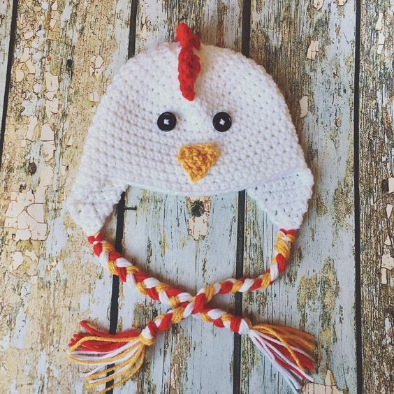 a crocheted chicken hat on top of a wooden table