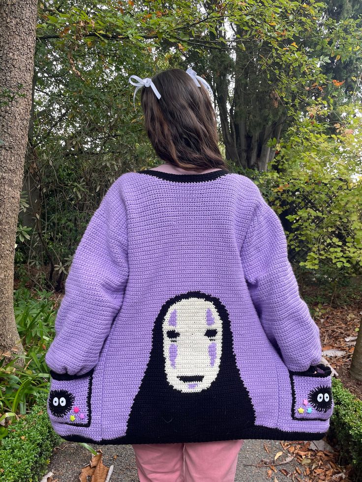 the back of a woman's sweater with an image of a face on it