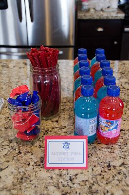 there are many bottled water bottles on the kitchen counter with red, white and blue straws