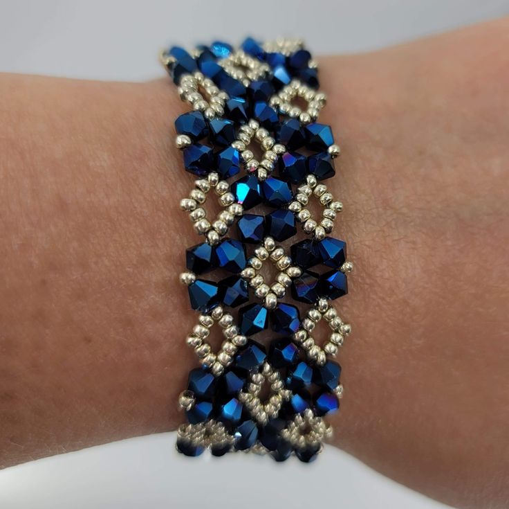 a close up of a person's arm wearing a bracelet with blue and silver beads