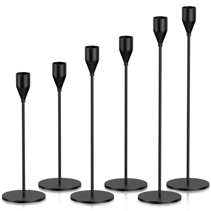 five black candles are lined up in a row on the same stand, with one candle between them