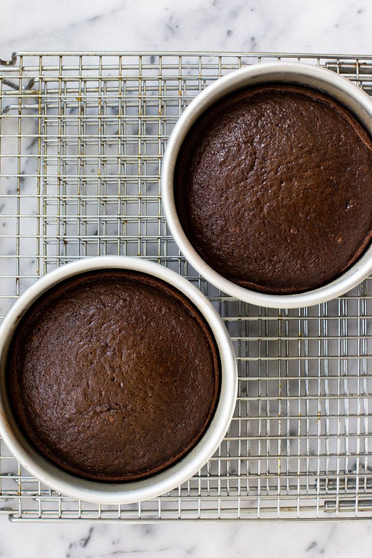 two brownies sitting on top of a cooling rack next to each other in white bowls