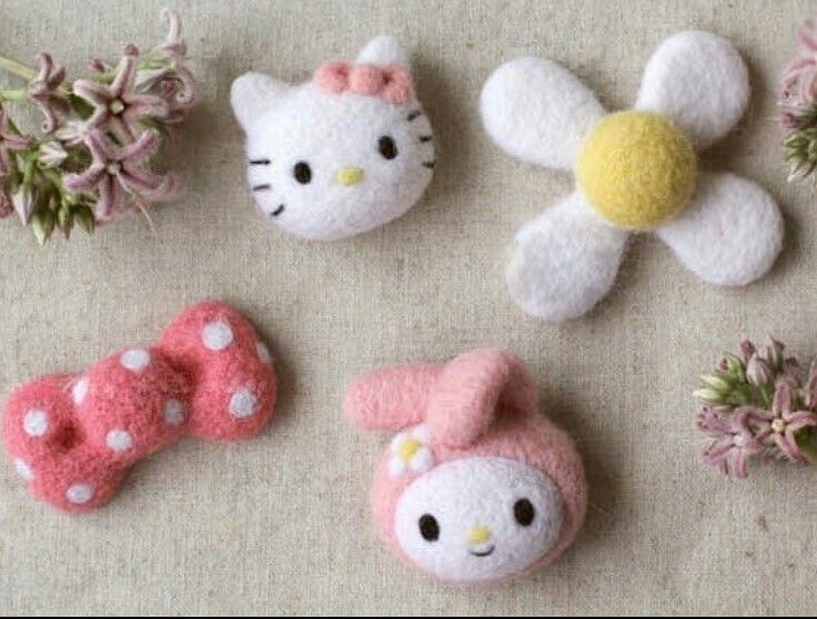 hello kitty broochies are arranged on a table next to pink flowers and daisies