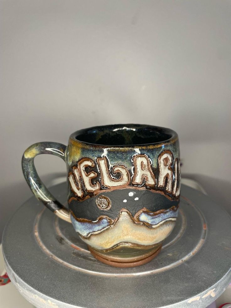 a coffee cup with the word elgar on it sitting on top of a plate