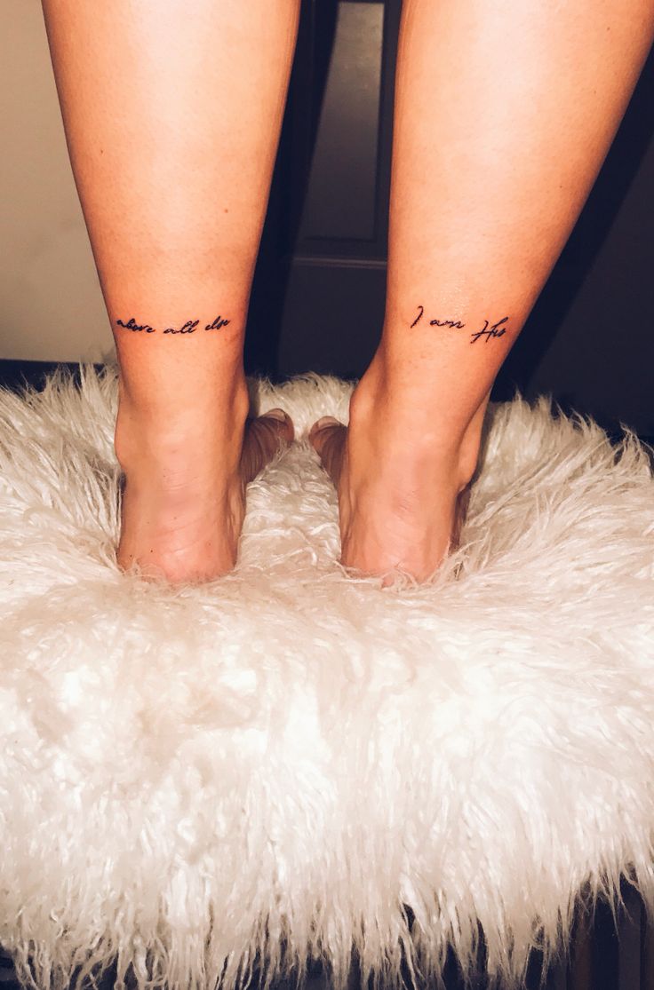 the legs of a woman with tattoos on their ankles and feet, standing on a fluffy white rug