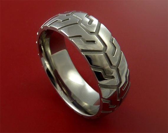 a wedding ring with an intricate design on it's side, against a red background