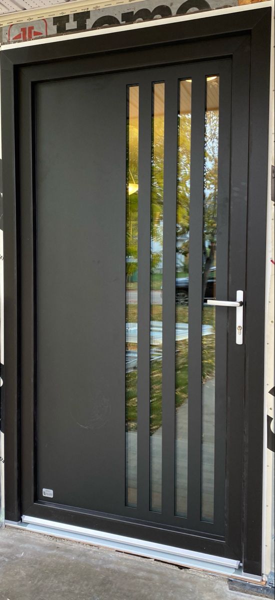 a black front door with glass panels on the sides and side doors that are closed