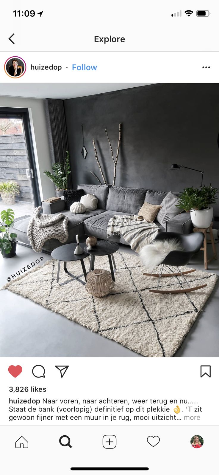 a living room with grey couches and white rugs on top of the floor