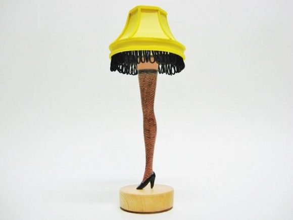 a lamp that is sitting on top of a wooden stand with a yellow shade over it