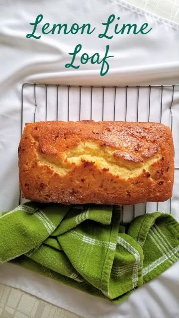 a loaf of lemon lime loaf sitting on top of a cooling rack next to a green towel