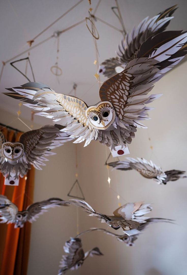 an owl mobile hanging from the ceiling with other owls in it's flight formation