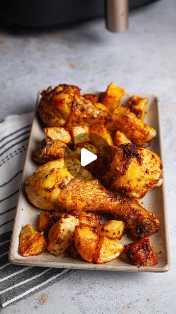 a white plate topped with chicken wings and potatoes next to an instant pressure cooker