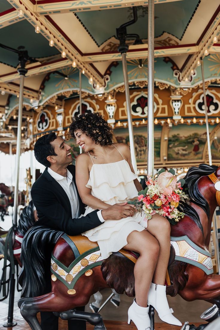 a man and woman sitting on a merry go round