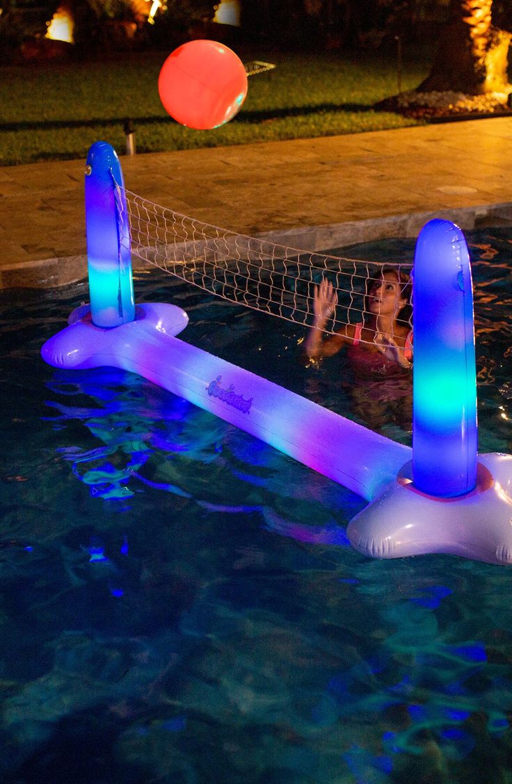 an inflatable water volleyball game is being played on the pool's edge