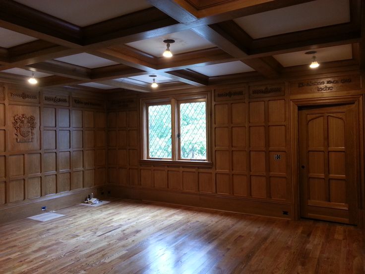 an empty room with wood paneling and wooden floors