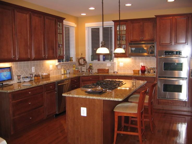 a kitchen with wooden cabinets and an island in front of the stove top ovens