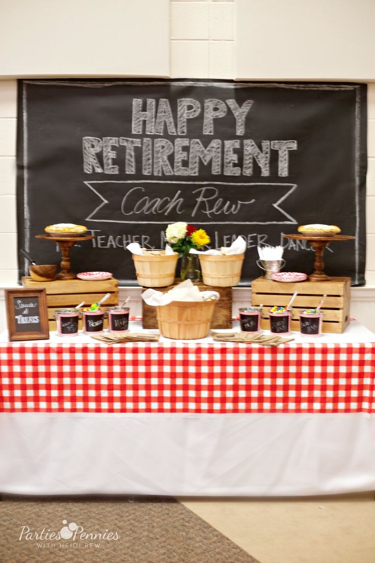 a table topped with baskets filled with food next to a chalkboard sign that says happy retirement