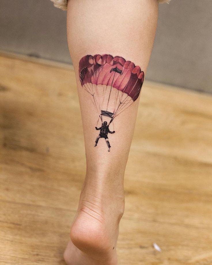 a person with a tattoo on their leg holding a parachute