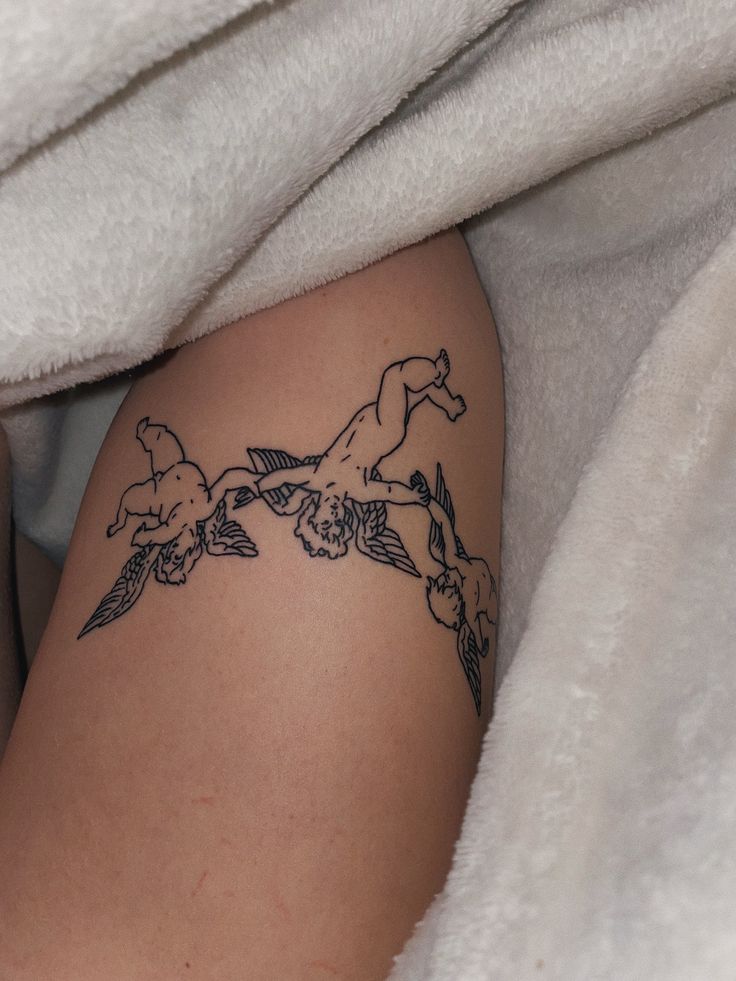 a woman with a tattoo on her leg under a white blanket is laying in bed