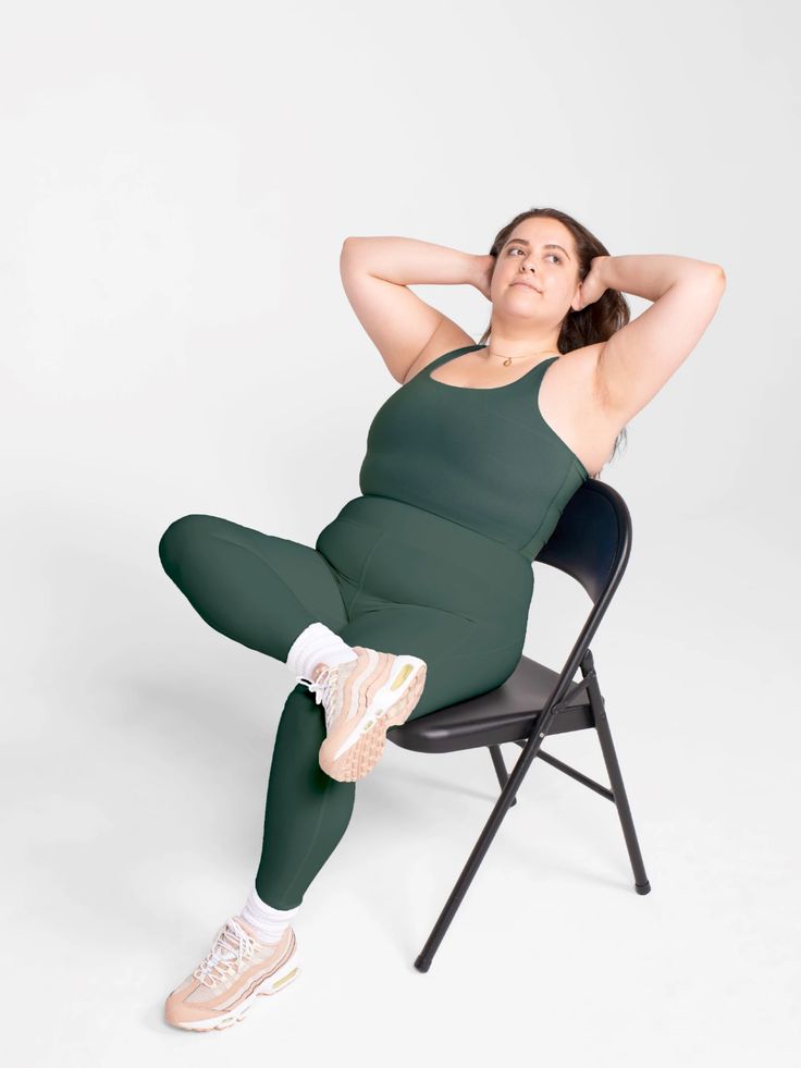 a pregnant woman sitting in a chair with her legs up and hands behind her head