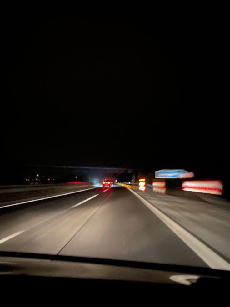 a car driving down a highway at night