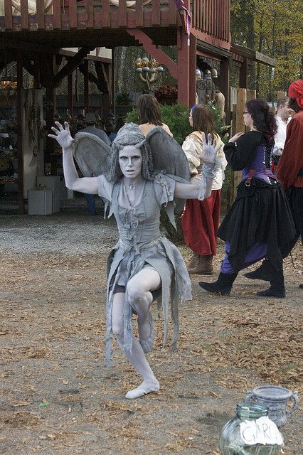 a woman dressed as a fairy dancing in the dirt