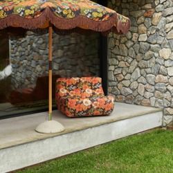 an umbrella and chair are sitting outside on the concrete step in front of a stone wall