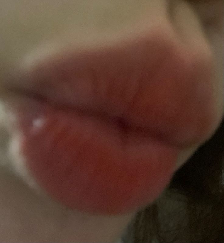 a close up view of a person's lips with the tongue sticking out to the side