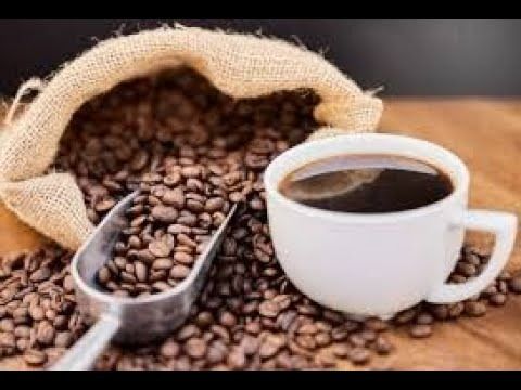 a cup of coffee sitting on top of a pile of coffee beans