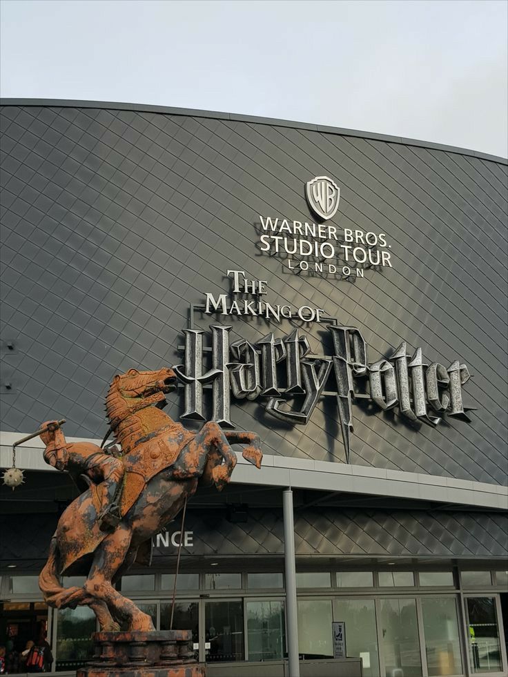 a statue of a man riding a horse in front of a hogwarts studio