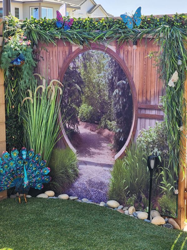 an outdoor garden with a wooden fence and peacocks