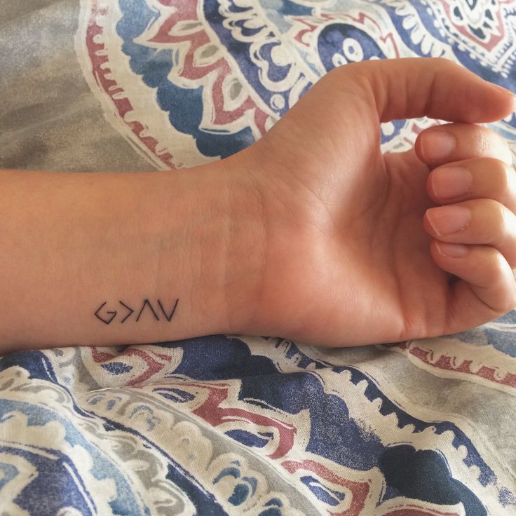 a person's arm with a small tattoo that says omg on the wrist