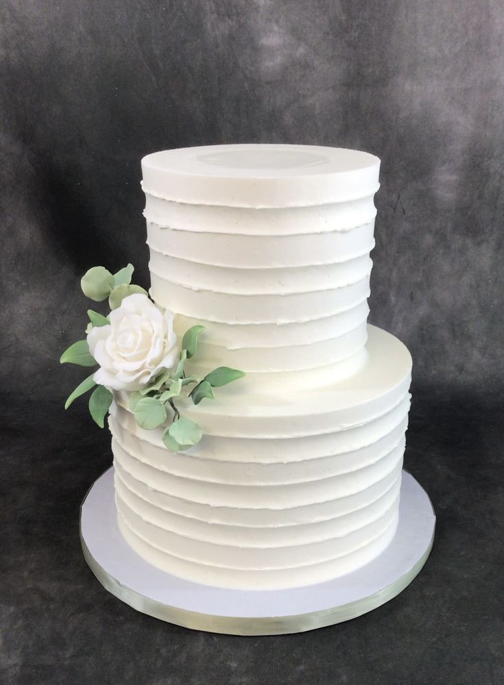 there is a white cake with flowers on the top and bottom tiers that are stacked together